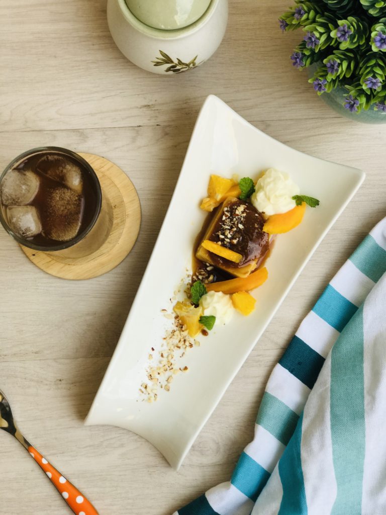 Toffee Creme Bruleé with fresh mangoes and oranges paired with Iced Cafe Americano